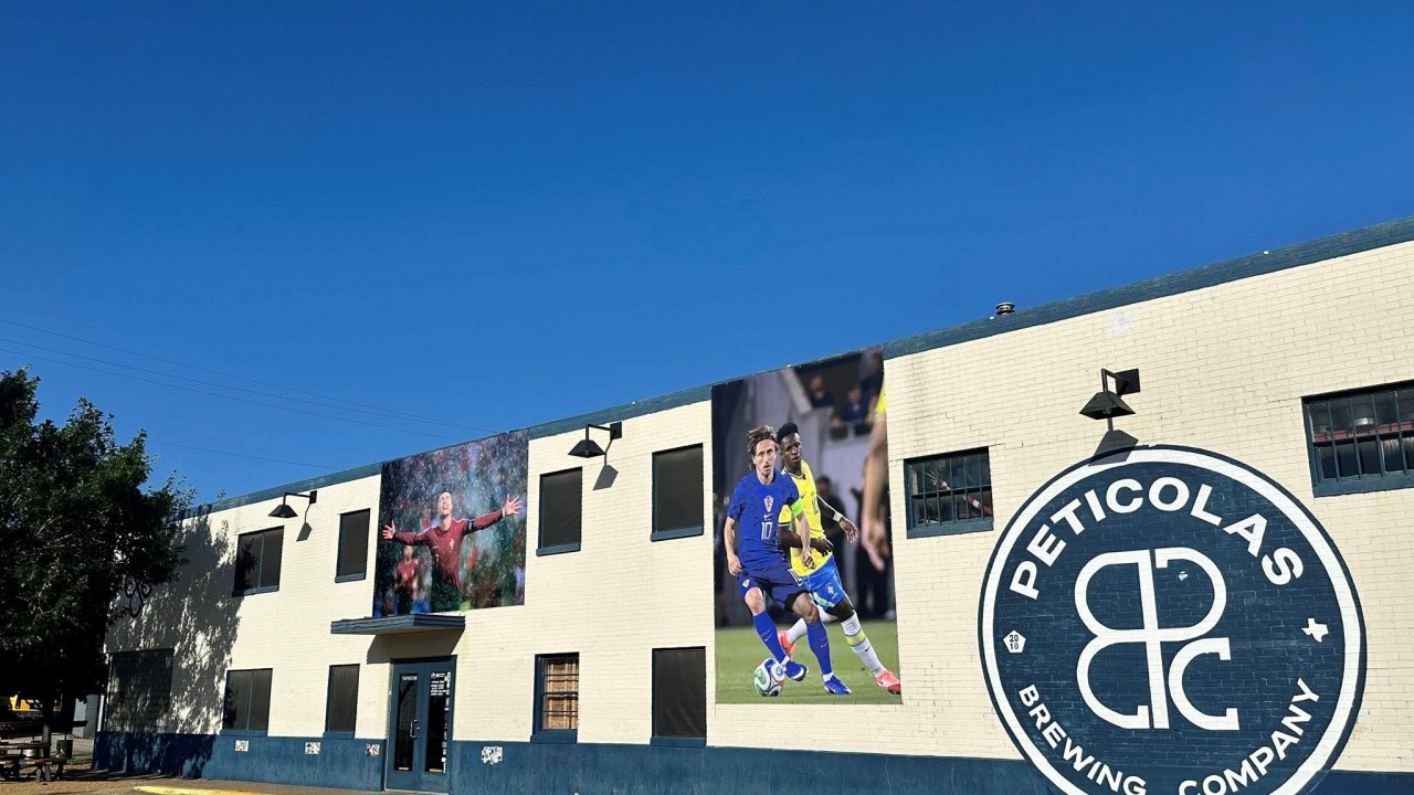 Exterior Installations at Peticolas Brewing Company include the famed “Ronaldo in the Rain” photo by Marcelo Guelber Goes