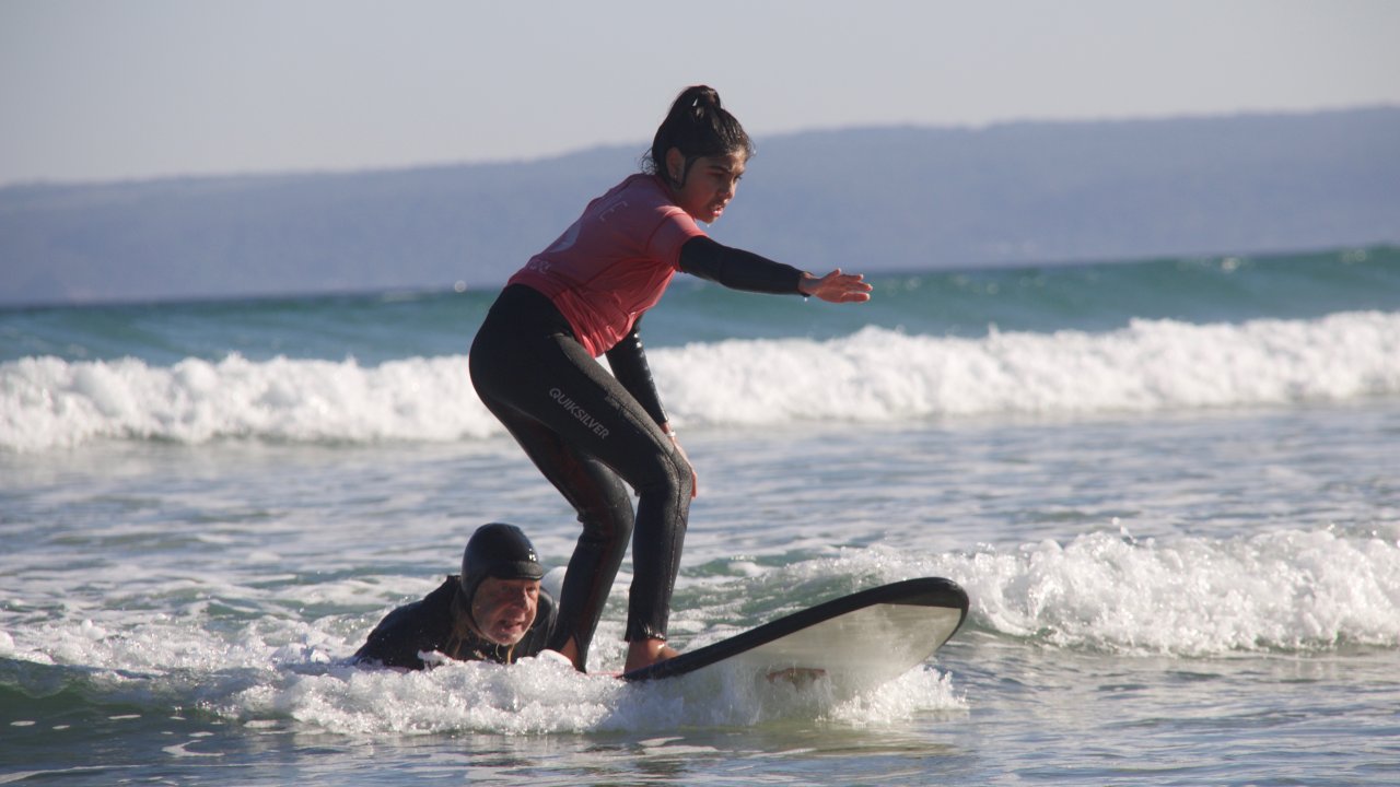 'Bones' helping a student catch her first wave - Offshore Surf School Inverloch 