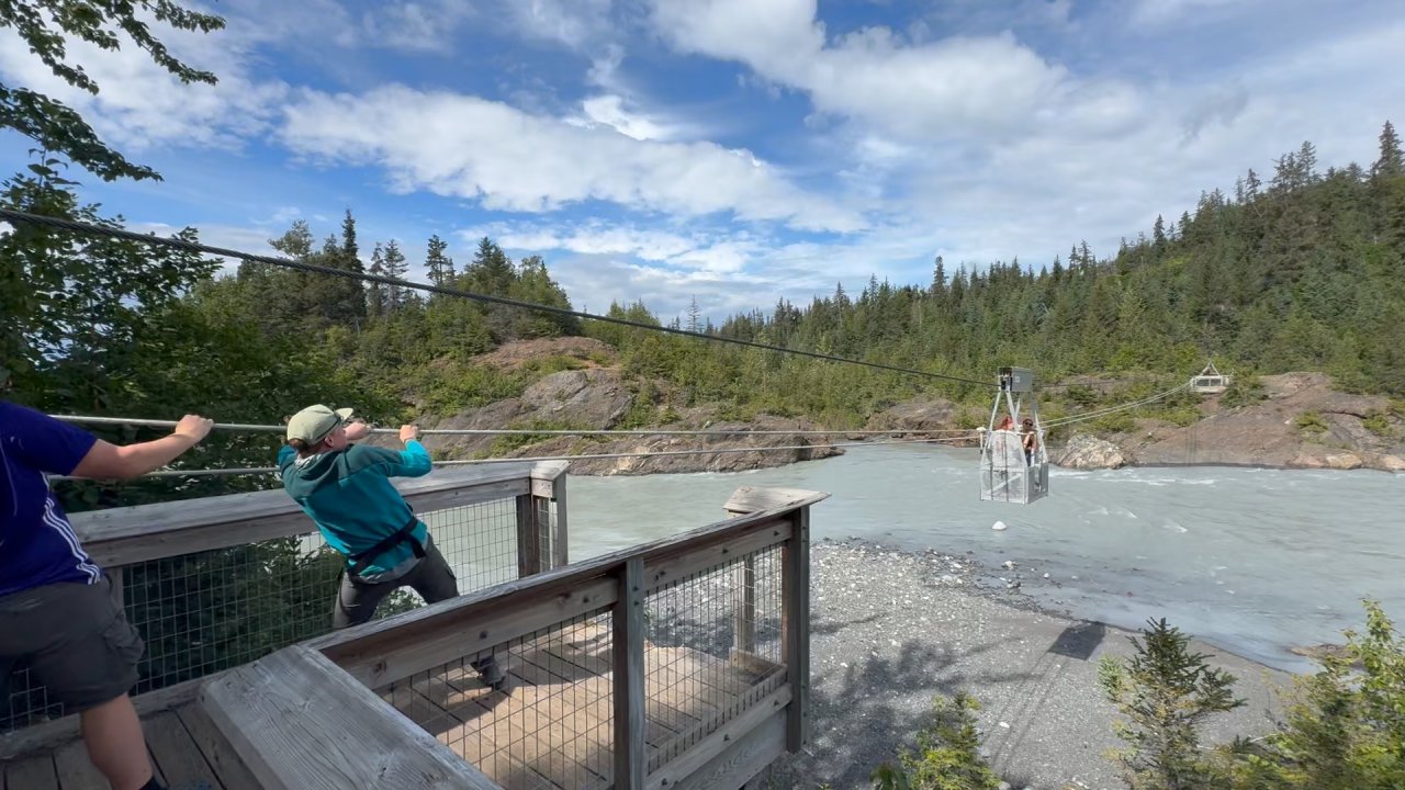 Participants maneuver themselves across the Grewingk River on the hand tram. 