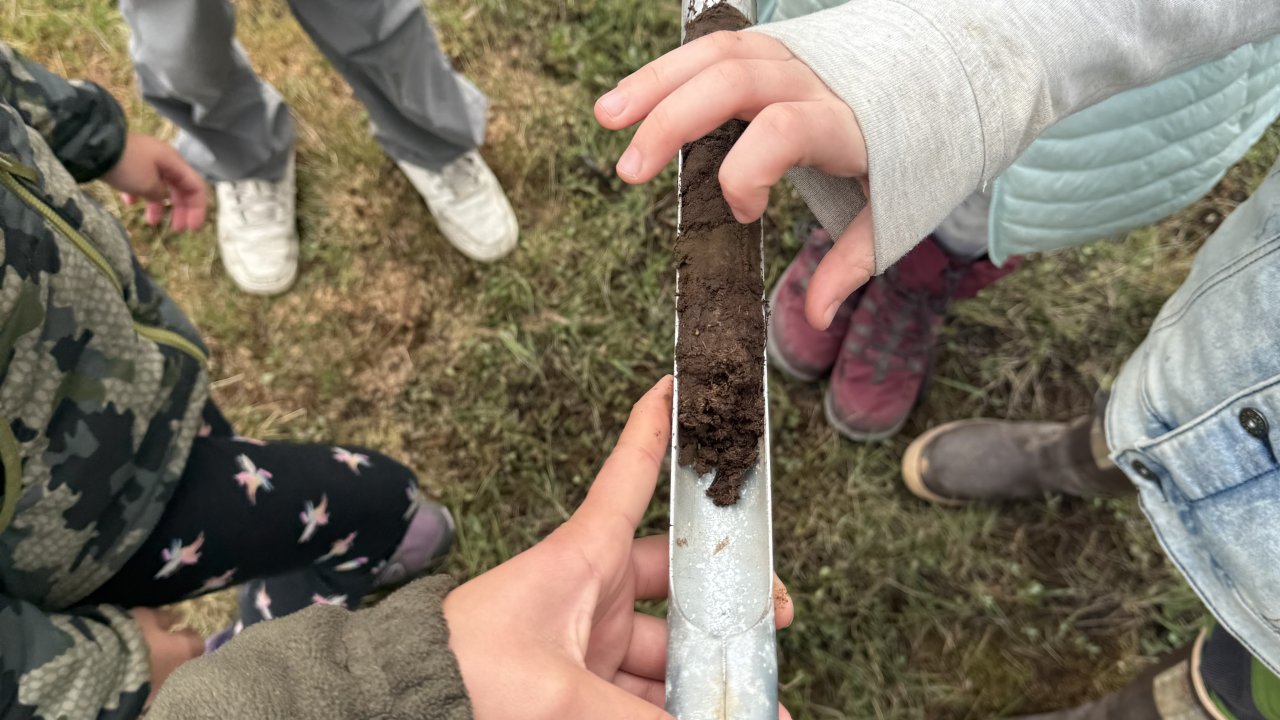 Campers examine a peat core in the Wynn's bog.