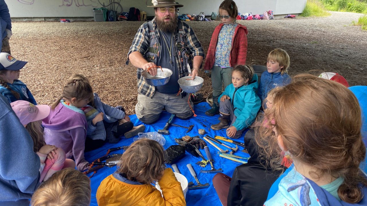 An educator gives a lesson about paleontology at the Anchor River.