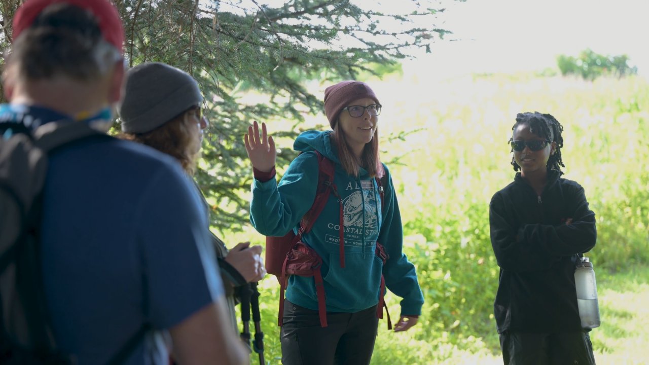 A naturalist giving interpretive information on a guided tour. Credit Twolined Studio.