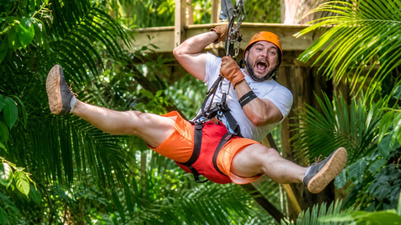 Guest ziplining through the Belize rainforest canopy